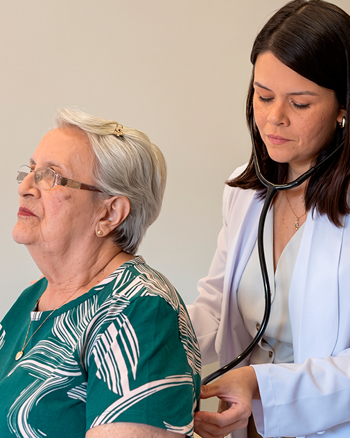 Dra. Luana realizando ausculta em uma paciente idosa durante consulta